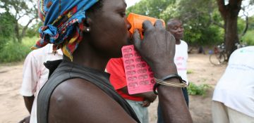 Person affected by leprosy taking her medicine                